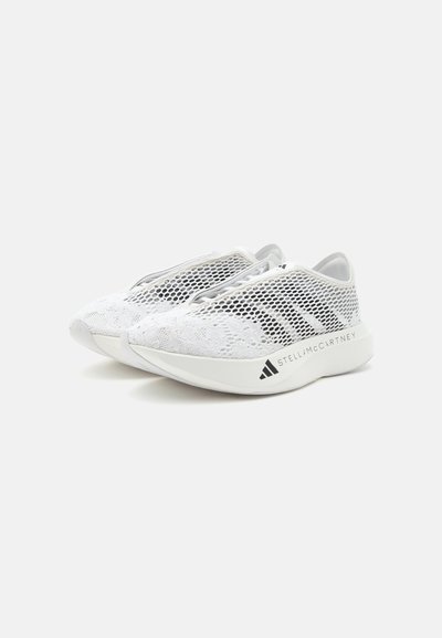 Ζευγάρι λευκά slip-on sneakers με επίστρωση από δίχτυ, λεπτομέρειες με κορδόνια και τη σήμανση "Stella McCartney" στις πλατφόρμες.