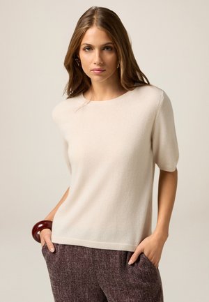 Hellbeige kurzärmliger Pullover mit rundem Ausschnitt aus weichem Material, der über gerippte Details an Saum und Bündchen verfügt.