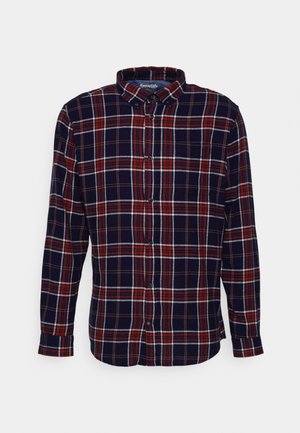 Camicia a scacchi nei colori blu navy, rosso e bianco; presenta un colletto button-down, maniche lunghe e una tasca frontale. Tessuto strutturato.