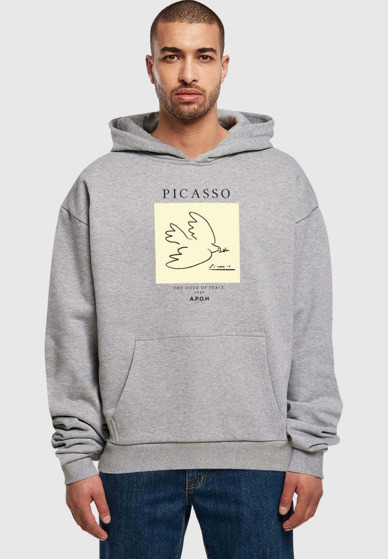 Grå hætte sweatshirt med en forlommer, der har et trykt design af en due og tekst af Picasso, lavet af blødt stof.