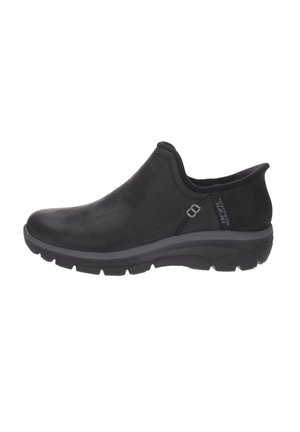 Scarpa nera slip-on con suola ammortizzata, punta arrotondata e tacco basso, con etichetta laterale che riporta "Skechers Slip-Ins."