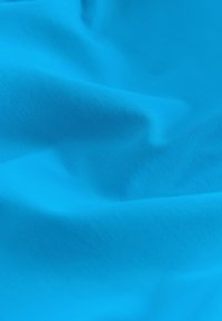 Tissu bleu vif avec des plis doux et une texture fine, créant des ombres et des reflets subtils sur le matériau.