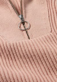 Rosa gestrickter Pullover mit einem Viertel-Reißverschluss-Design, ausgestattet mit einem silbernen Metallreißverschluss und einem gerippten Muster.