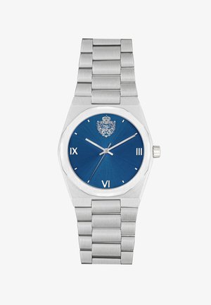 Reloj de acero inoxidable con un dial texturizado azul, caja octagonal, marcadores de hora plateados y una pulsera articulada. Cuenta con una corona en el lateral.