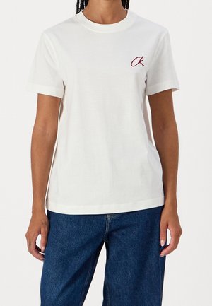 White cotton t-shirt with short sleeves, ribbed crew neckline, and small burgundy embroidered logo on the chest. Straight fit, smooth texture.