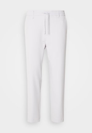 White tapered pants with an elastic waistband, drawstring closure, smooth texture, and no visible patterns or accents.