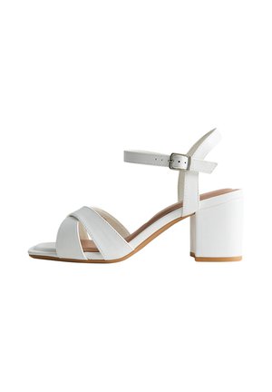 Sandalia blanca de punta abierta con amplias tiras cruzadas, correa ajustable en el tobillo, tacón cuadrado y acabado liso. Suela beige que realza el diseño.