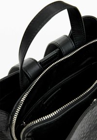 Borsa a mano in pelle nera con esterno texturizzato, dettagli in zip argento e manico corto. Interno foderato, che presenta numerosi scomparti.