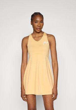 Jasnopomarańczowa sukienka tenisowa bez rękawów, z dekoltem w serek i krojem w linii A. Z logo w kolorze białym na piersi.