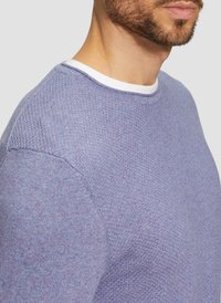 Paarse gebreide trui met een gestructureerd patroon. Heeft een witte ronde halslijn en een nauwsluitende pasvorm die de zachtheid van de stof benadrukt.
