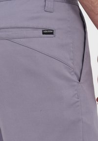 Graue Volcom-Shorts aus strukturiertem Stoff, mit einer Gesäßtasche und einem Logodruck sowie schrägen Nähten für einen maßgeschneiderten Look.