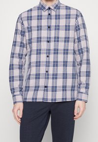 Napapaita napakaduvi sinisestä ja harmaasta ruudullisesta kuviosta, joka on valmistettu kevyesti teksturoidusta kankaasta. Paidassa on klassinen kaulus ja pitkät hihat.