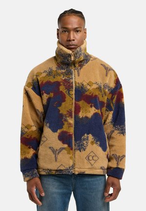 Fleece jacket featuring a beige base with multicolored abstract patterns in blue, red, and yellow. High collar and front zipper detail.