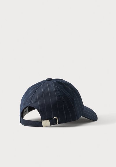 Casquette de baseball bleu marine à fines rayures avec sangle réglable à boucle métallique, vue de dos sur une surface blanche.