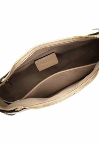 Schwarze Tasche mit beigem Stofffutter, einem Reißverschluss und einer großen Tasche mit einem kleinen Etikett. Glatte Textur mit goldfarbenen Beschlägen.