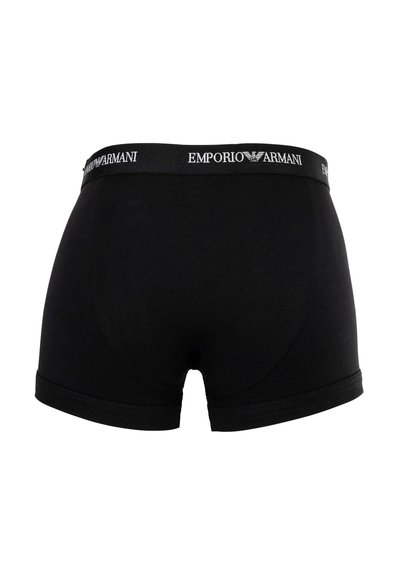 Μαύρα ανδρικά μπόξερ με ελαστική μέση που φέρει το λευκό λογότυπο Emporio Armani και το έμβλημα αετού, εμφανιζόμενα από πίσω.