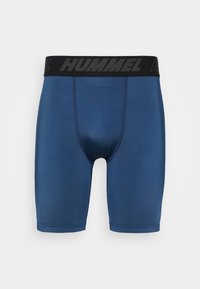 Blå idrottsshorts med svart midjeband med "HUMMEL" i fet stil. Slät textur och åtsittande passform lämplig för sport.