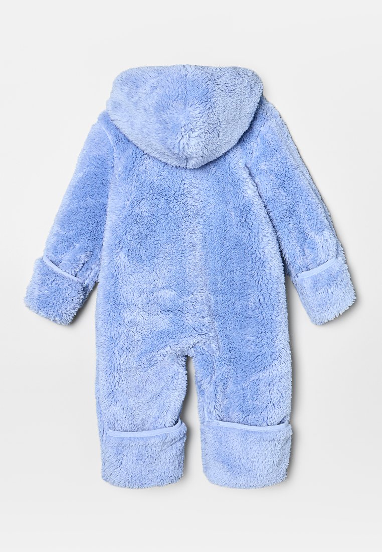 Mono de felpa azul con capucha, que presenta una superficie suave y texturizada y puños enrollados en las muñecas y tobillos.