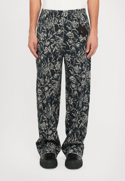 Pantalons à motif floral noir et blanc avec une taille élastique et deux poches latérales, fabriqués en tissu léger.
