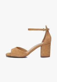 Tan suede heeled sandals with an open toe, an ankle strap, and a square block heel, featuring a smooth texture and simple design.
