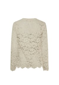 Beige bluse af blonder med lange ærmer, blomstret mønster, bølget kant og V-formet rygdesign, der fremhæver en sart og tekstureret finish.