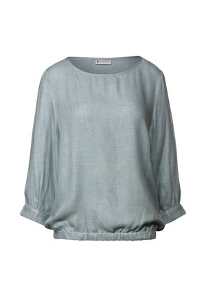 Vaaleansininen, löysä blusa, joka on valmistettu pehmeästä ja teksturoidusta kankaasta. Siinä on kolmen neljänneksen hihat ja kerätty helma.