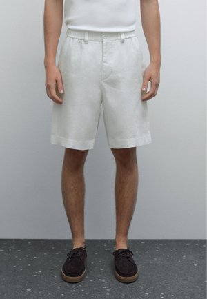 White linen shorts with a flat front, elastic waistband, and side pockets. The fabric has a lightweight, textured appearance.
