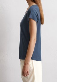 Mörkblå t-shirts med kort ärm och rundad halsringning, tillverkad av mjukt bomullsmaterial, med en avslappnad passform och en slät yta.