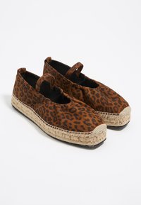 Pruun leopardimustriga espadrillid jute-köitega tallaga, ümarate varvaste ja kahe kangasilmaga kinnitamiseks. Ülemise osa sile tekstuur.