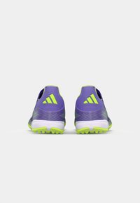 Purple athletic shoes with green accents, featuring a textured design, rounded back, and rubber traction sole for grip.