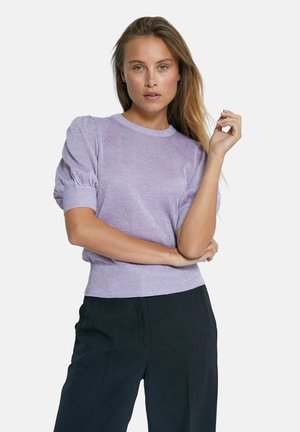 Ljuslila, kortärmad stickad tröja med rund halsringning och puffärmar. Ribbad nederkant och muddar. Bärs tillsammans med svarta byxor.