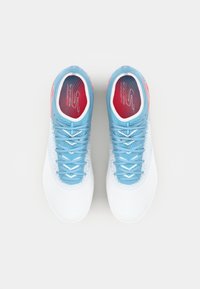 Baskets blanches avec des lacets et des accents bleus. Design texturé sur les côtés, avec une semelle intérieure rouge et blanche. Vue de dessus.