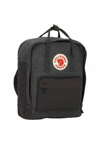 Mochila gris de felpa con acentos negros, que cuenta con un bolsillo frontal con cremallera y un parche circular de logo. Diseño duradero con asas superiores y correas.