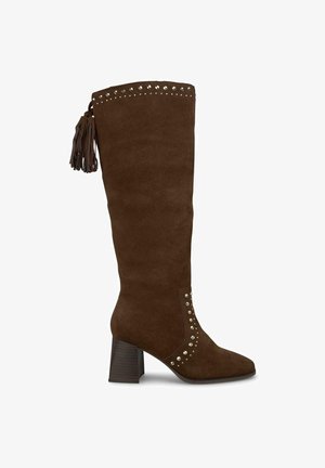 Bottines en suede marron, montant jusqu'au genou, avec un bout carré, un talon épais, des accents cloutés et un détail de franges. Présente une texture lisse et un design robuste.