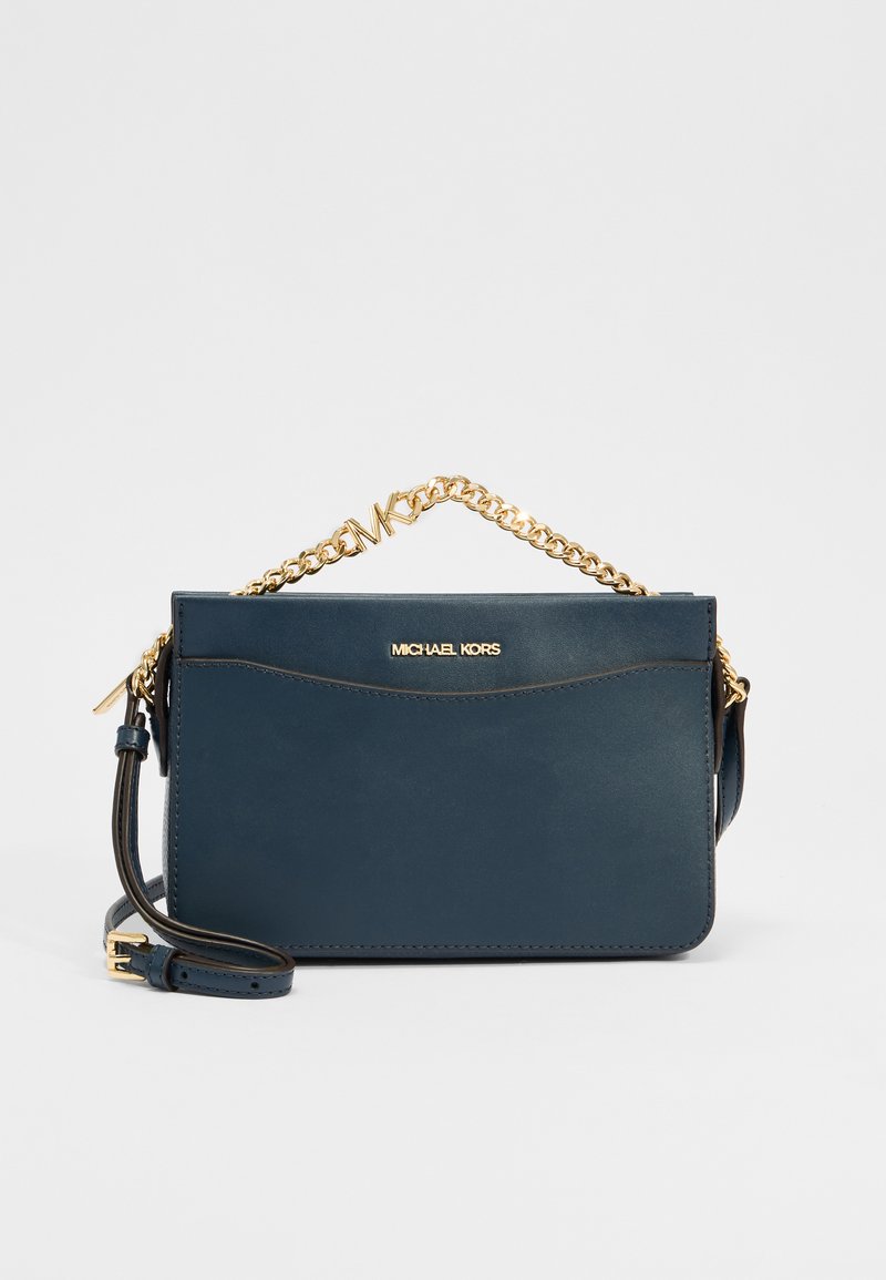 Marineblauwe leren schoudertas met gouden accenten, ketting en leren band, met een gebogen naaddetail en gegraveerd logo.