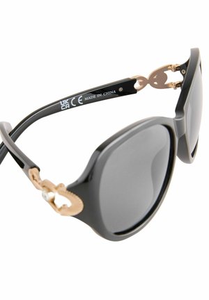 Ochelari de soare negri cu un finisaj lucios, lentile supradimensionate și accente din metal auriu pe brate. Prezintă detalii de branding gravate.