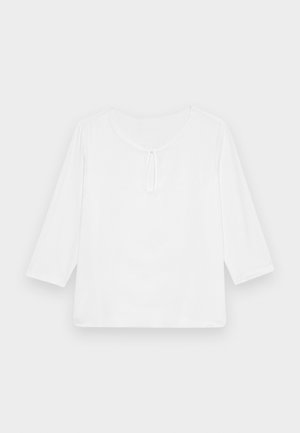 Witte, driekwart mouw, losse top met een ronde halslijn en een kleine sleutelgaatje aan de voorkant. Gladde textuur, geen patronen.
