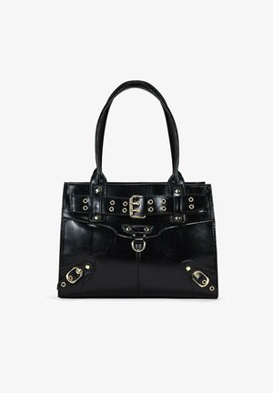 Bolso de mano de cuero sintético negro con dos asas, detalle frontal de cinturón con herrajes dorados y tachuelas, y acentos laterales con cierres metálicos.