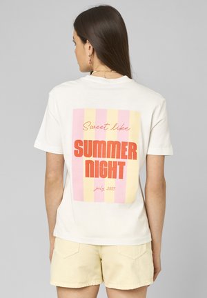 Femme aux longs cheveux bruns portant un t-shirt blanc à rayures roses et jaunes avec un texte rouge « Sweet like SUMMER NIGHT july 2005 », associé à un short beige.