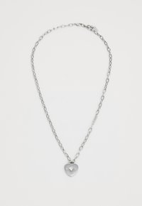 Silver metal necklace with linked chain, featuring a heart-shaped pendant engraved with "GUEST AMORE" and two clear stones.