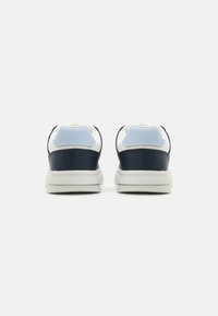 Marinblå lädersneakers med vita accenter och en ljusblå hälflik. Rundad form, vadderad krage och texturerade gummisulor.