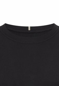 Sort bomuld T-shirt med rund halsudskæring, glat tekstur og synlige sømme. Har en lille hvid detalje på bagsiden af halsen.