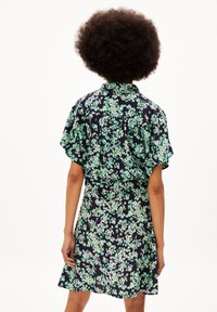 Robe florale noire marine avec des motifs verts et roses, manches courtes, col à boutons, taille cintrée et jupe évasée.