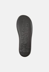 Black rubber insole featuring textured surface with raised dots and engraved branding "ENERGI HUMAN" and "42" at the bottom.