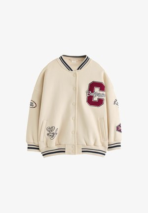 Beige varsityjakke med stribet krave og manchetter, trykknapper og patches inklusive en stor rød "C" og "California" tekst på brystet.
