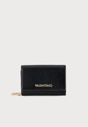 Clutch Valentino de piel negra con logo dorado en el frente y una pequeña cadena dorada, sobre un fondo claro y liso.