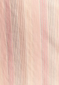 Tessuto di stoffa con strisce verticali in rosa chiaro, beige e viola chiaro. La texture appare liscia con un motivo intrecciato.