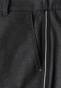Schwarze Stoffhose mit geradem Schnitt, ausgestattet mit einem weißen Akzentstreifen entlang der Seite und einem kleinen Metallelement in der Nähe der Tasche.