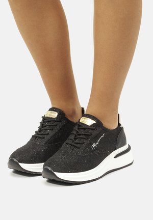 Scarpe da ginnastica nere con superficie testurizzata, suola bianca, design con lacci e dettagli dorati. Presentano un particolare distintivo sul lato.