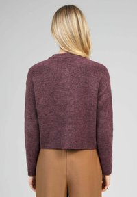 Pull court bordeaux en matière douce et texturée. Il présente des manches longues et un col rond. Sans marque ni motifs visibles.
